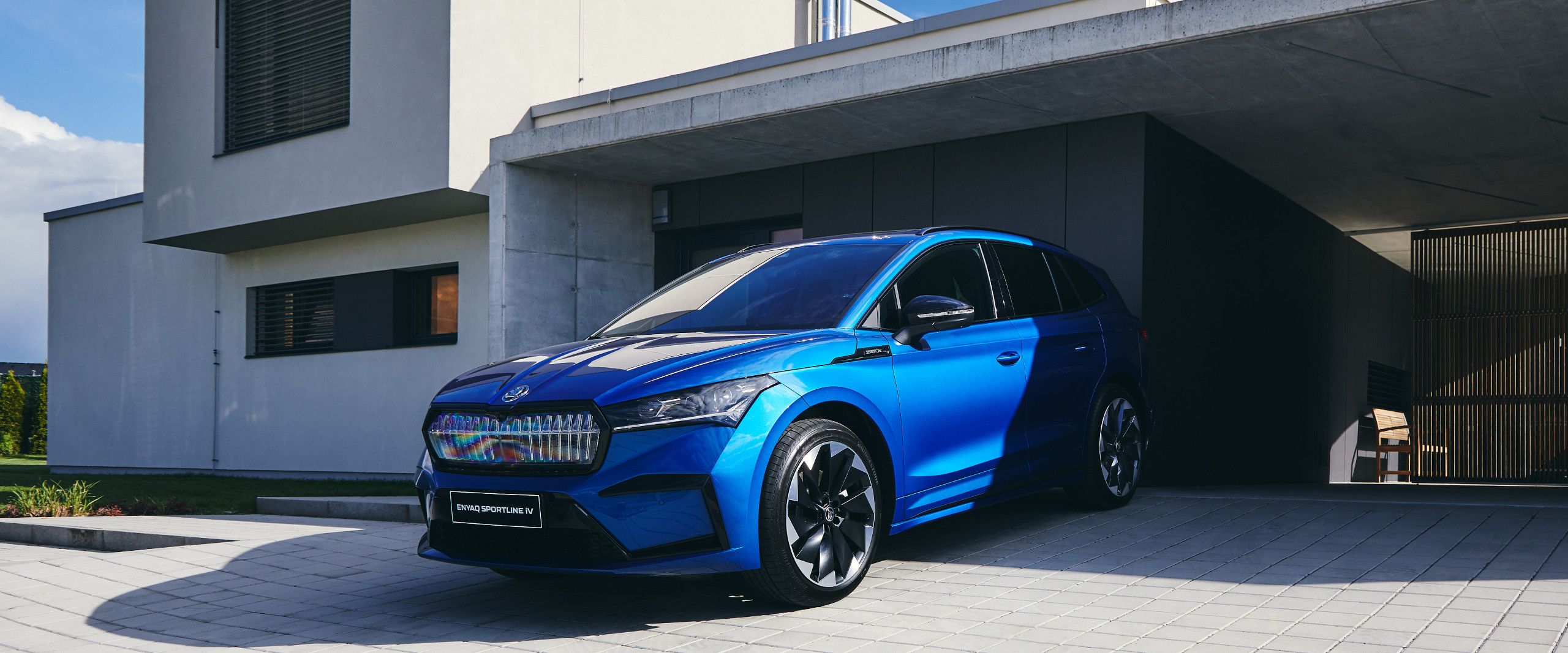 Skoda Enyaq in blau vor einer Garage